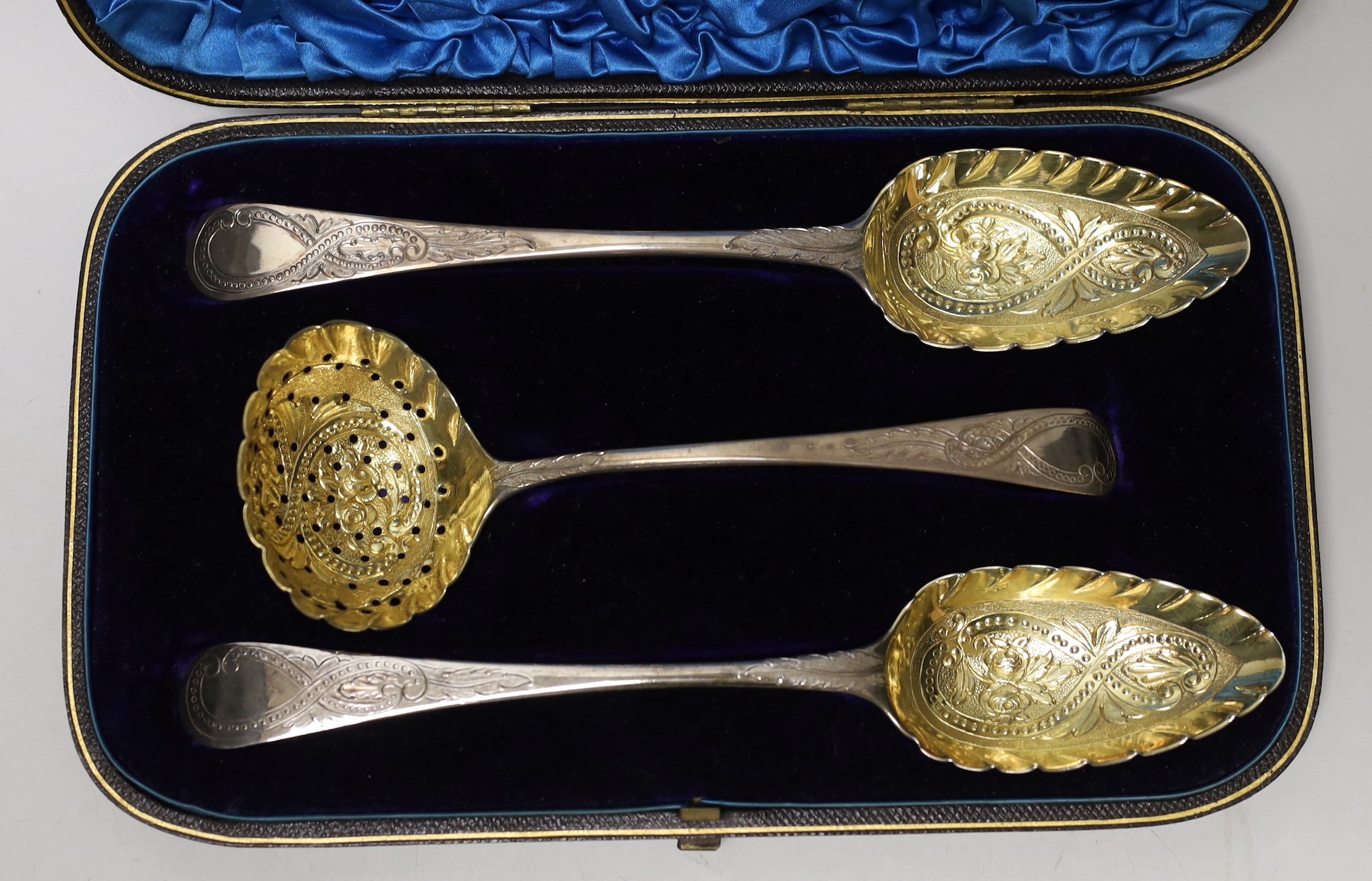 A cased set of two George III parcel gilt silver spoons and a matching sifter spoon, George Burrows, London, 1795 and George & Alice Burrows, London, 1802, largest 22.1cm.